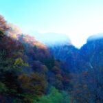 朝の光に照らされ、紅葉に包まれた称名滝周辺の峡谷