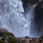 巨大な岩壁に激しく落ちる称名滝の水流。飛び散る水しぶきと立ち上る白い水煙が、迫力ある景観を生み出している。