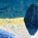 湖面に映る焼岳の黄葉と前景の岩。秋の風景を対比的に捉えた写真
